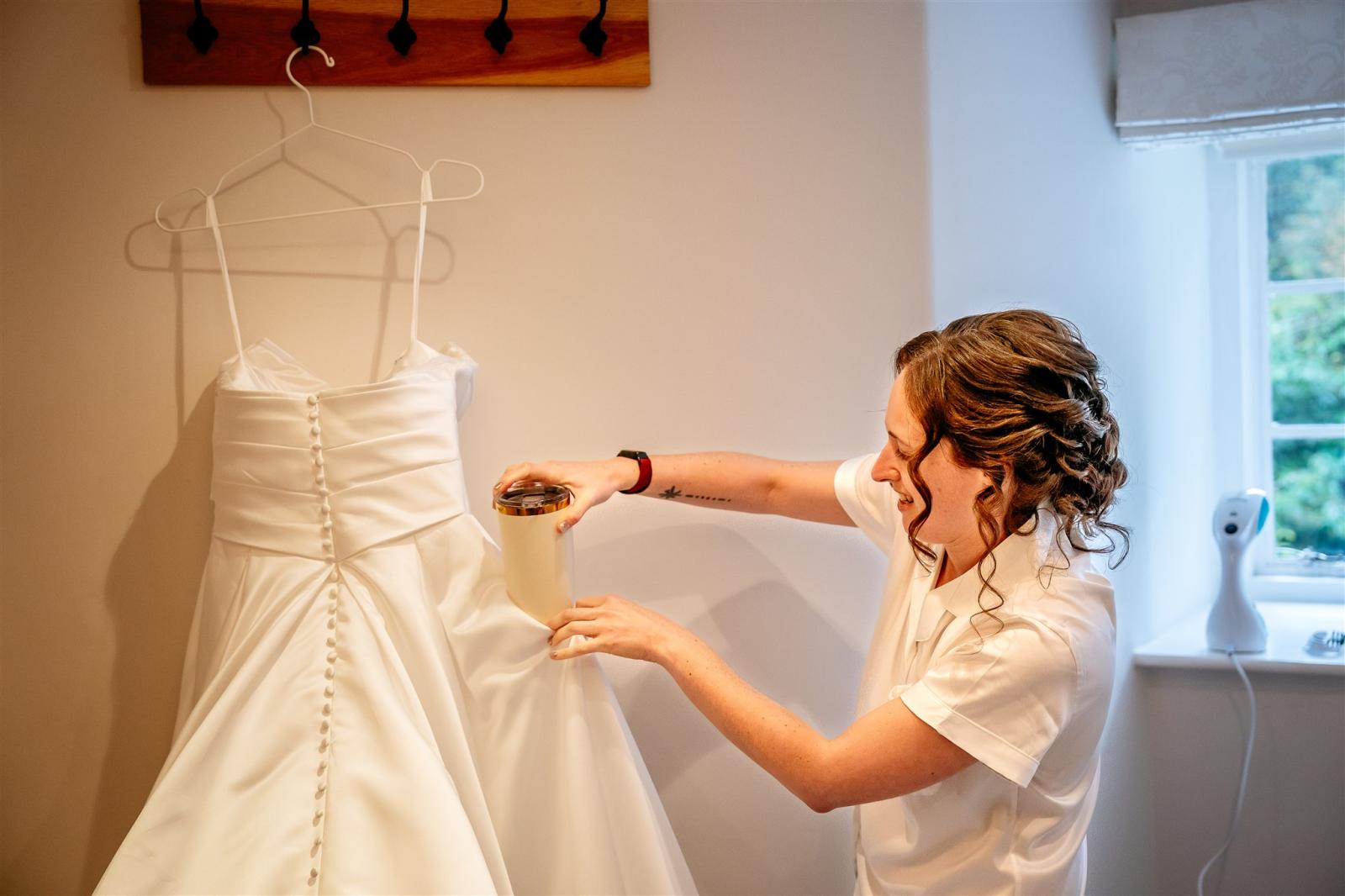 bride putting teacup into her  wedding dress pocket