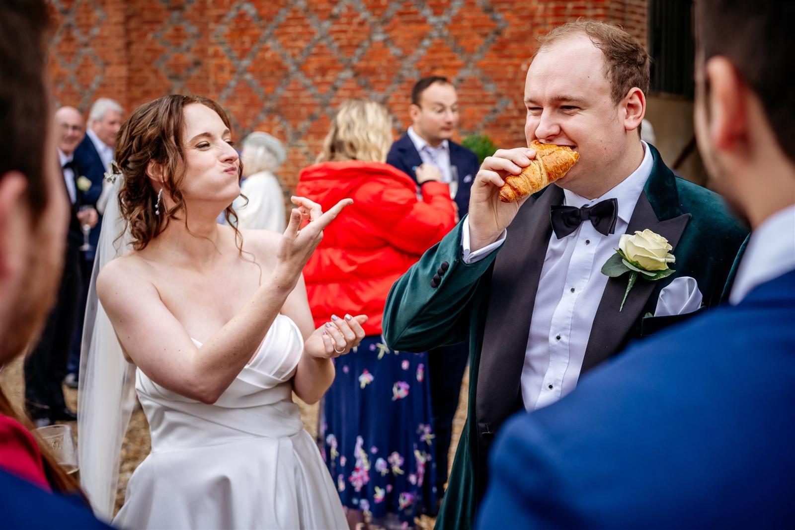 bride and groom Brideeatingcroissant Farnham Castle